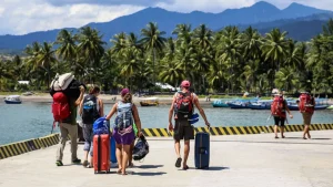 Tourists with luggage just arrived at Bangsal Lombok Harbor, starting their Lombok adventure after a fast boat from Bali.