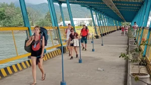 Travelers walking on the dock at Bangsal Lombok Harbor, the main arrival and departure point for Gili Islands ferries.