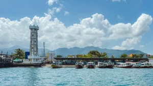 Bangsal Lombok Harbor view with docked boats and the iconic white tower - bustling port connecting Bali to Lombok and the Gilis.