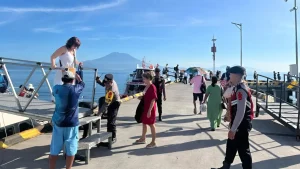 Passengers safely disembarking at Banjar Nyuh Harbor with assistance from port police and boat crew, organized arrival after a trip from Sanur to Banjar Nyuh.