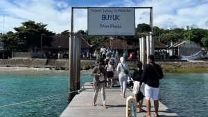 Passengers just arrived and walking on the jetty at Buyuk fast boat harbor, Nusa Penida, disembarkation point on the island's west coast.