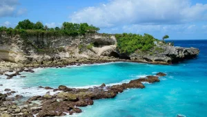 Stunning cliffside and pristine beach cove in Nusa Ceningan fast boat, showcasing the island's rugged and beautiful coastline.