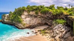 Dramatic green cliff tops meeting the blue sea in Nusa Ceningan, breathtaking natural landscape of the small island.