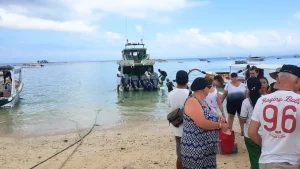 Tourists just arrived and walking ashore at Jungut Batu Beach, main landing spot for fast boats in Nusa Lembongan.