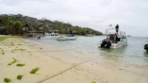 Fast boats anchored on the sandy shore of Jungut Batu Beach, iconic beachfront docking in Nusa Lembongan.