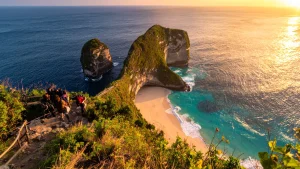 Golden sunset lighting up the T-Rex shaped cliff of Kelingking Beach in Nusa Penida, magical evening at the famous spot. prepared your trip from serangan to nusa penida for this spot