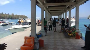 Lively scene at Padang Bai dock with vendors and boat crews preparing for departure, authentic harbor atmosphere in East Bali.